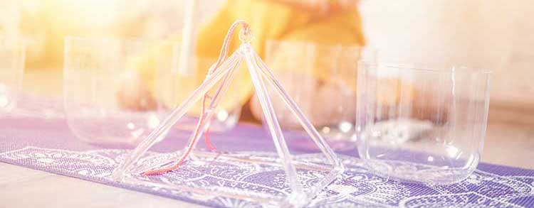 une séance de sonothérapie avec des bols et une pyramide en cristal